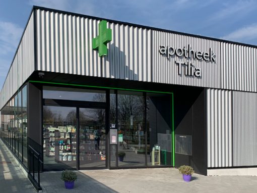 UNIVERSITAIR ZIEKENHUIS ANTWERPEN (UZA)<br><span style='color:#31495a;font-size:12px;'>De toegang tot de nieuwbouw commerciƫle apotheek ligt aan de zijde van het centrale wandelpad dat de verbinding vormt tussen de parking en de hoofdinkom.</span>